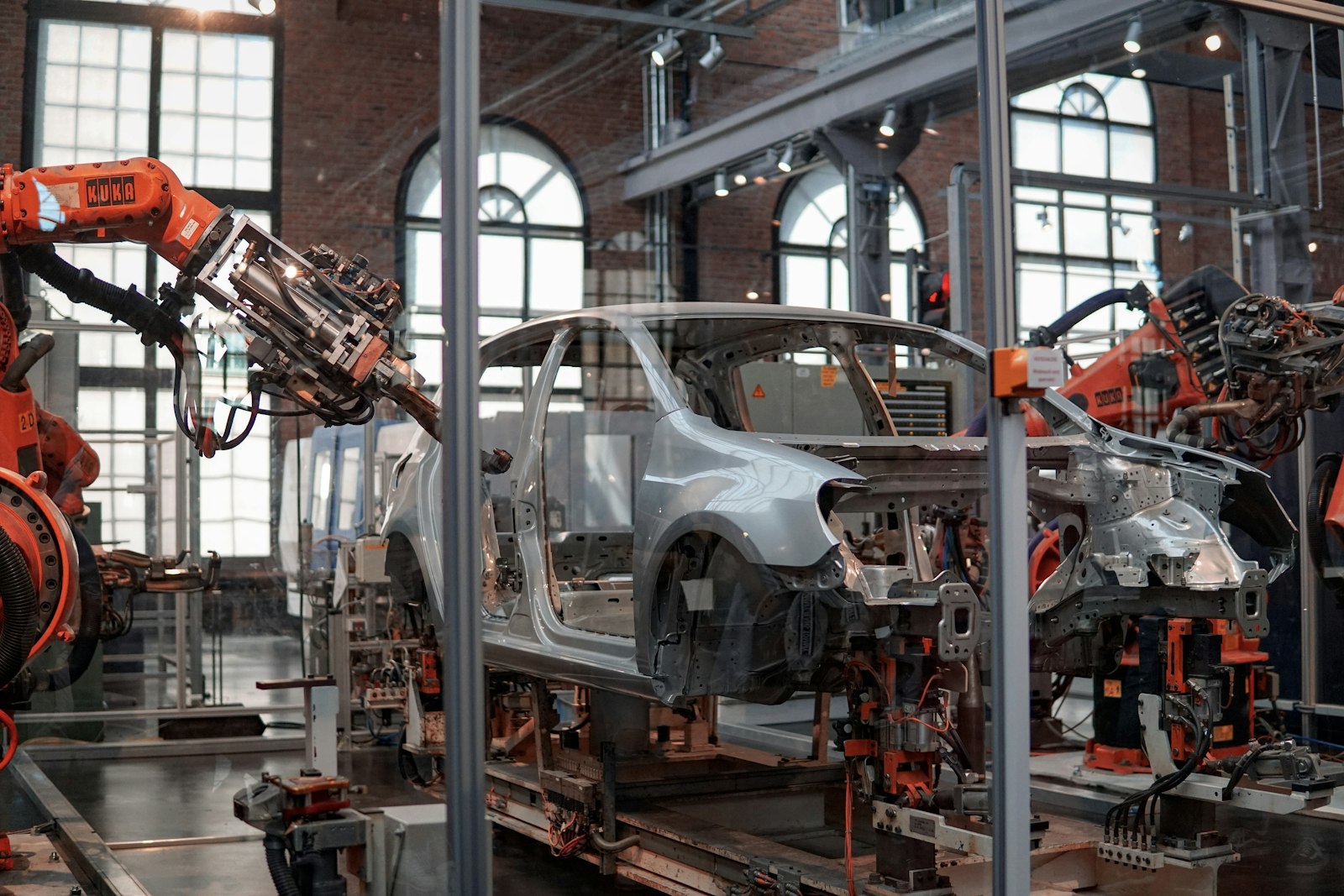 A car body on an automated assembly line surrounded by robotic arms in an automotive manufacturing facility
